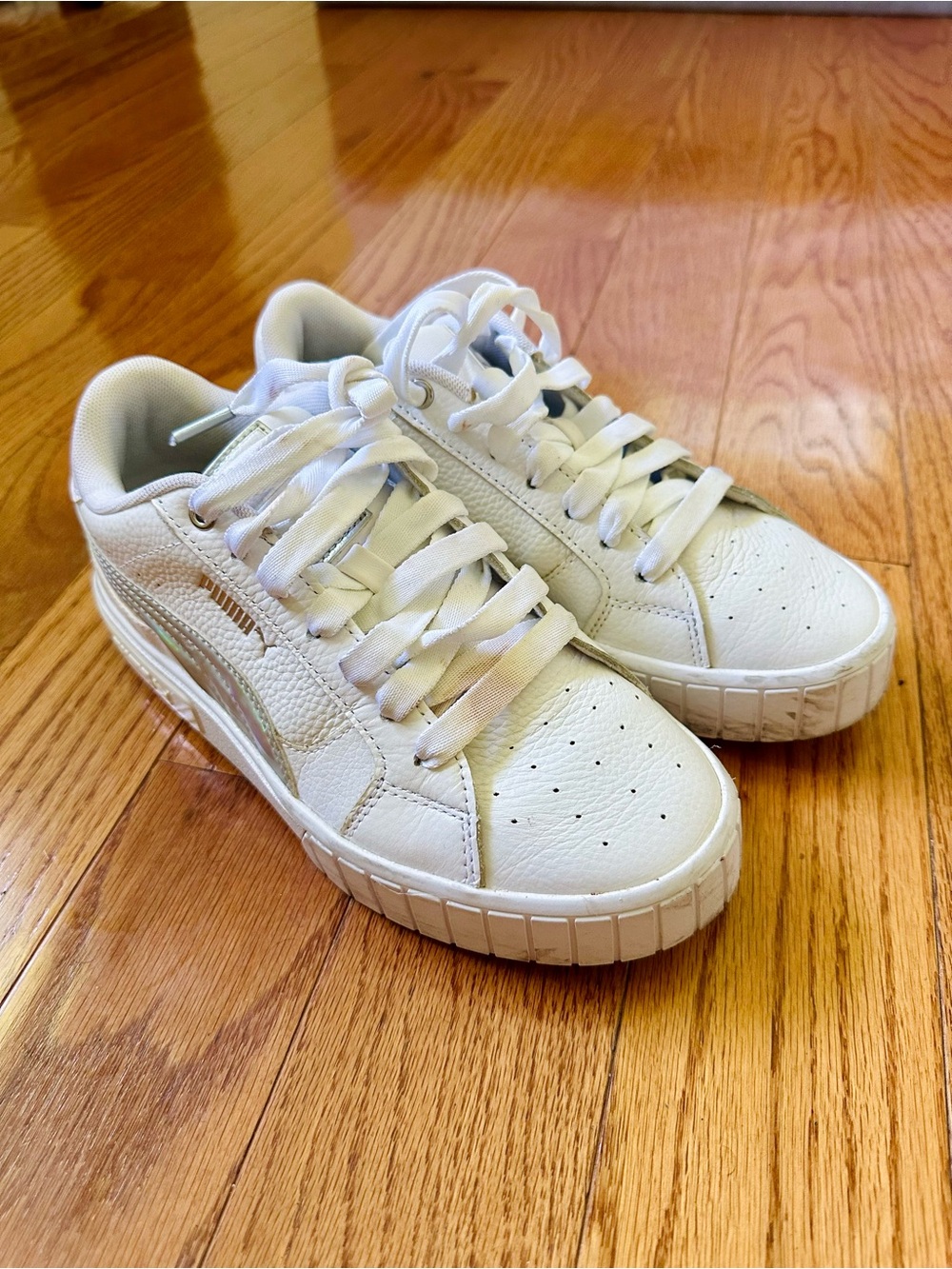 White Puma Cali Star Sneakers feature a sleek metallic accent